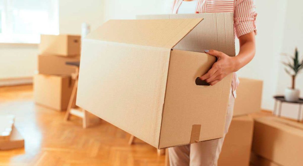 Mujer cargando una caja en una mudanza